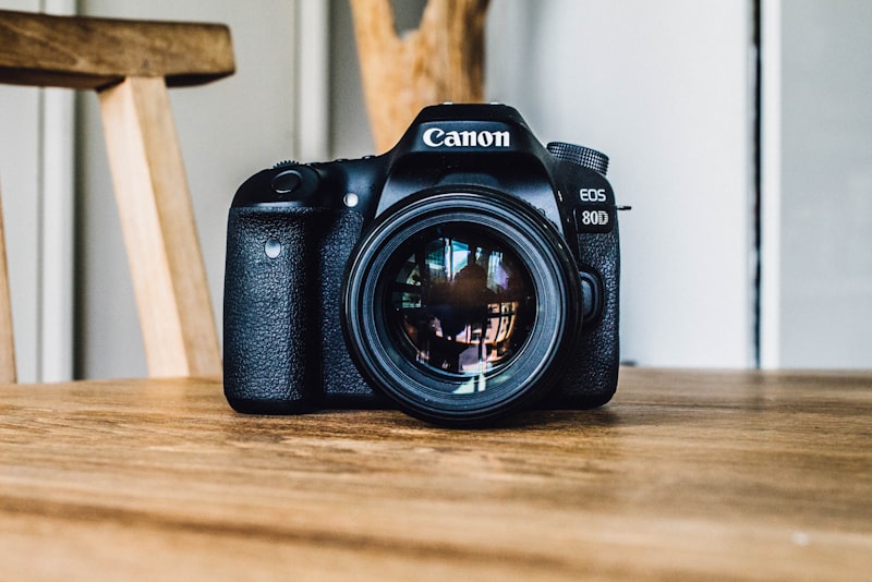 A camera lens seen from the front with its aperture blades forming a small hexagonal opening.