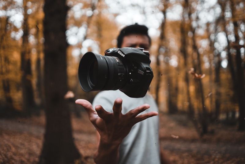 A photographer steadying a camera with both hands near a sunlit window